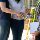 A couple shakes hands with a home builder holding a contract.
