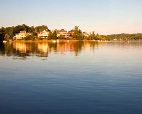 A lake surrounded by houses and trees.