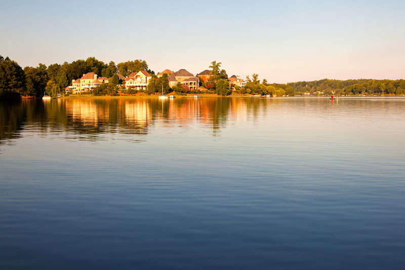 A lake surrounded by houses and trees.