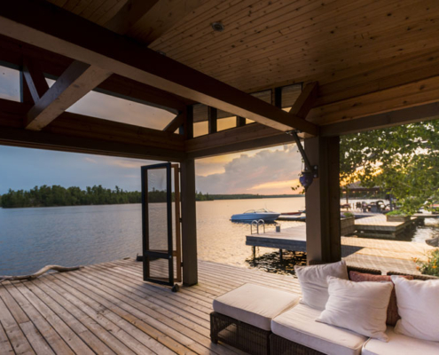 A covered deck outside a custom lake home.