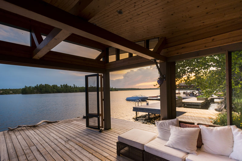 A covered deck outside a custom lake home.