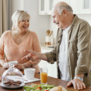 A couple of senior citizens standing in a kitchen for breakfast.