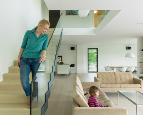 A woman walking down the stairs to her daughter in a two-story home.