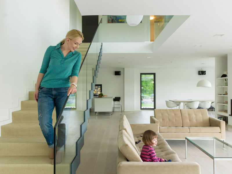 A woman walking down the stairs to her daughter in a two-story home.